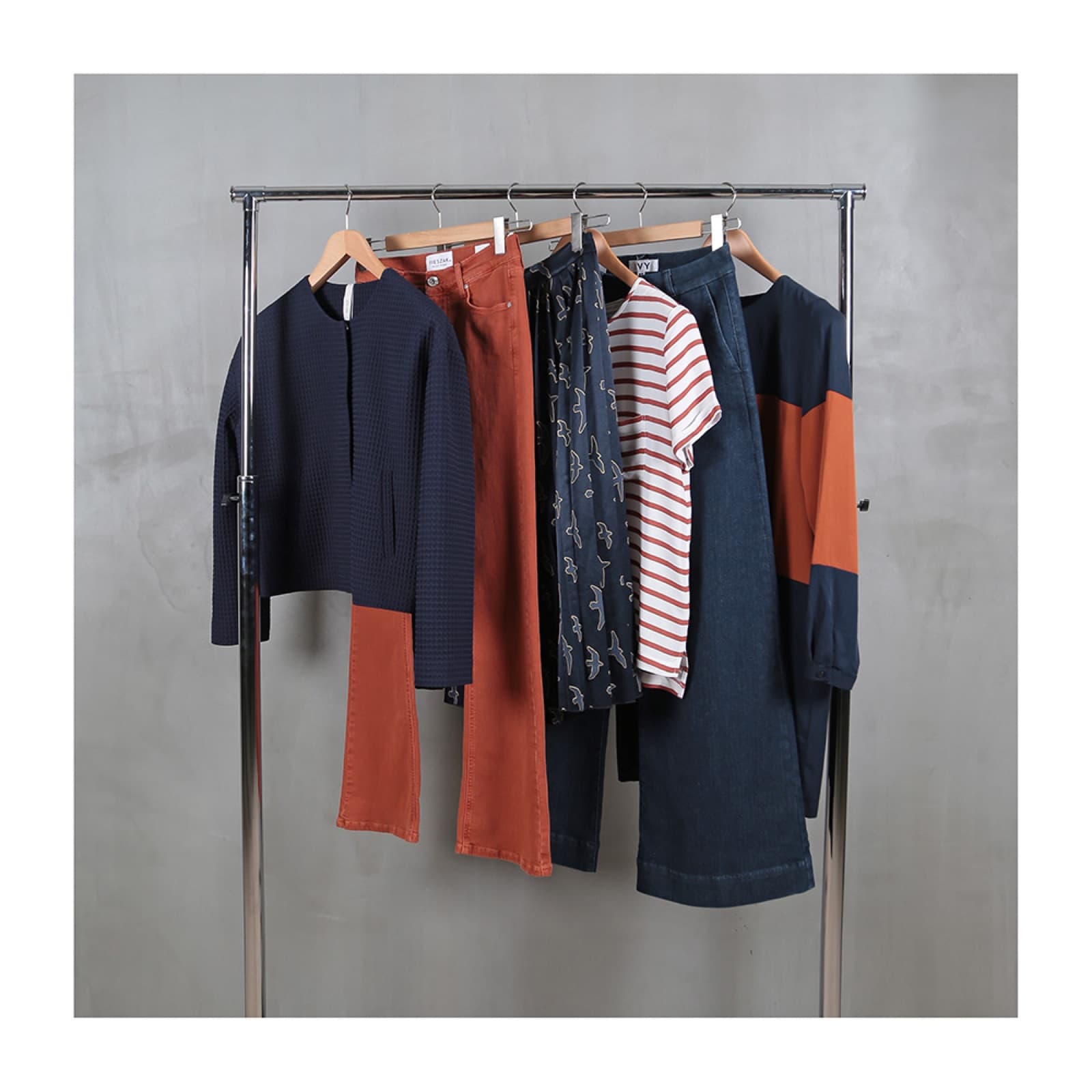 Casualwear collection on a rail: knits, trousers and printed pieces