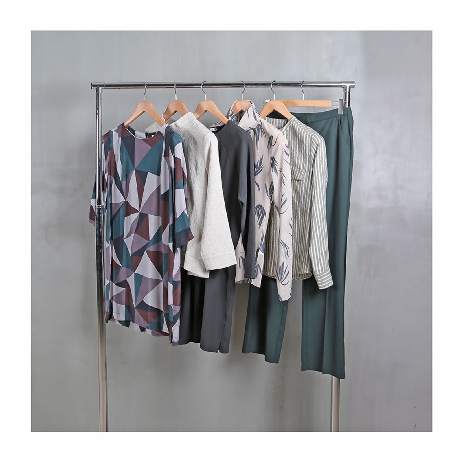 Womenswear collection on a rail: printed dress, knits, blouses and tailored trousers